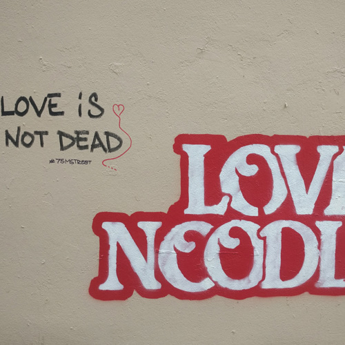 A photograph of graffiti that says love noodles