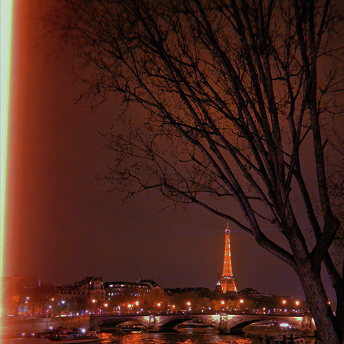 A photograph of a Paris street with the Eiffel tower in the distance